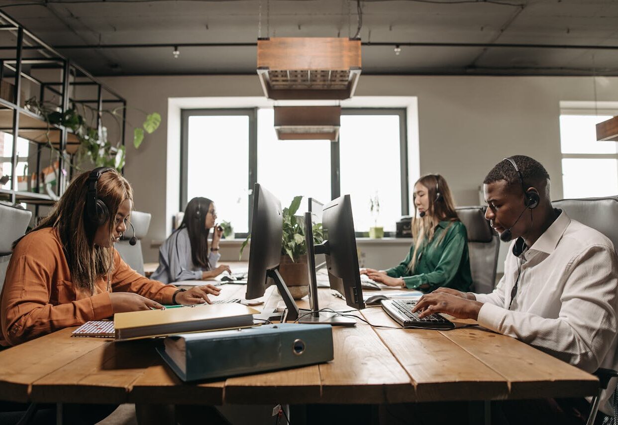 A diverse group of employees collaborating with headsets in a modern office setting.